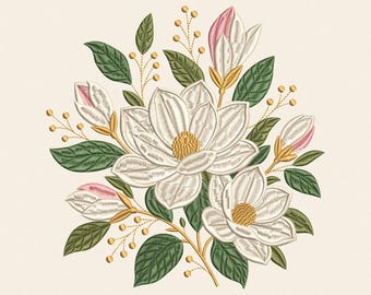 May include: An embroidery design featuring a cluster of white magnolia flowers with yellow centers, pink-tipped buds, and dark green leaves. Thin golden stems with small round yellow accents extend outward from the central floral arrangement.
