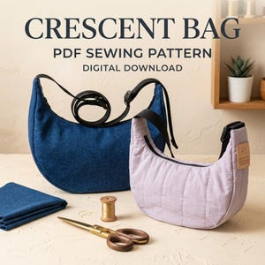 Peut inclure: Un patron de couture PDF pour sac croissant en téléchargement numérique, présentant un sac bleu foncé et un sac matelassé violet clair avec des sangles noires, accompagné d'un carré de tissu bleu plié, d'une bobine de fil dorée et de ciseaux dorés.