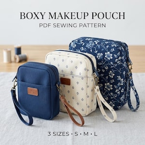 Puede incluir: Tres neceseres rectangulares en tallas S, M y L, con un patrón de costura en PDF. Los neceseres son de color azul marino liso, crema con un pequeño estampado geométrico azul y azul marino con un estampado floral blanco, cada uno con correa.