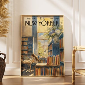 May include: A framed print of The New Yorker magazine cover dated July 1, 1974, featuring a watercolour illustration of a library interior with tall blue bookshelves, a large window, a vase of blue and white flowers, and people reading at tables.