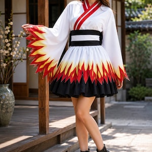 May include: A white dress with long, wide sleeves featuring a red and yellow flame pattern at the cuffs and hem. The dress has a red and white striped collar, a wide black and white striped waist sash, and a black pleated skirt. Black ankle boots.