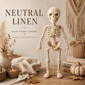 Crochet skeleton amigurumi featuring an ivory cream color throughout the skull and complete skeletal body. The figure has a recognizable skull with hollow-looking eye areas, a small nasal opening and teeth, followed by layered crocheted ribs, spine, pelvis, arms with fingers, and segmented legs. The neutral color and textured yarn give the anatomical figure a soft handmade appearance.
