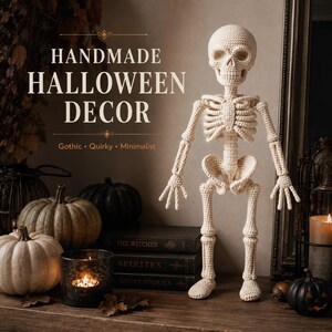 Crochet skeleton amigurumi figure shown full length in soft cream yarn, with a detailed skull, rib cage, spine, pelvis, arms, individual fingers, long legs, knees, and rounded feet. The front-facing design clearly displays skeletal anatomy recreated with crochet stitches, making this a distinctive crocheted skeleton decoration or Halloween-themed amigurumi figure.