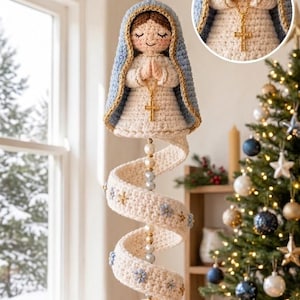 May include: A crocheted hanging ornament featuring a figure with a blue and gold-trimmed mantle, a white dress, and hands in prayer holding a gold cross necklace. A long, spiralling white crocheted tail decorated with small blue flowers and beads.