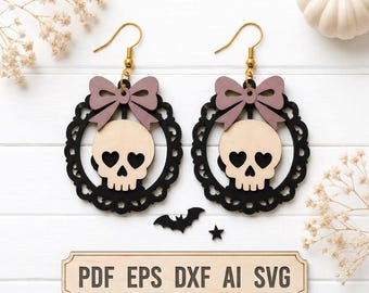 May include: A pair of dangle earrings featuring a light-colored skull with heart-shaped eye sockets centered within a black scalloped circular frame, topped with a mauve bow and gold-toned hooks. Includes a rectangular sign reading PDF EPS DXF AI SVG.