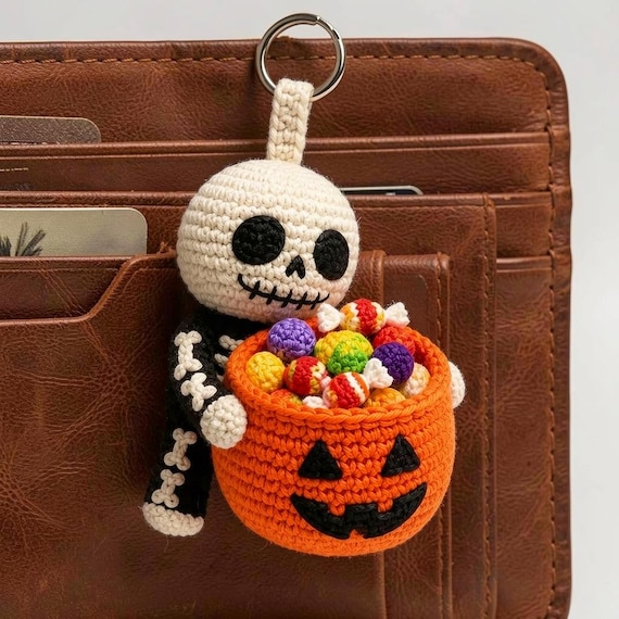 A crocheted oversized skeleton candy bucket that doubles as a bag charm — handmade, spooky-cute, and absurdly specific in the best way.