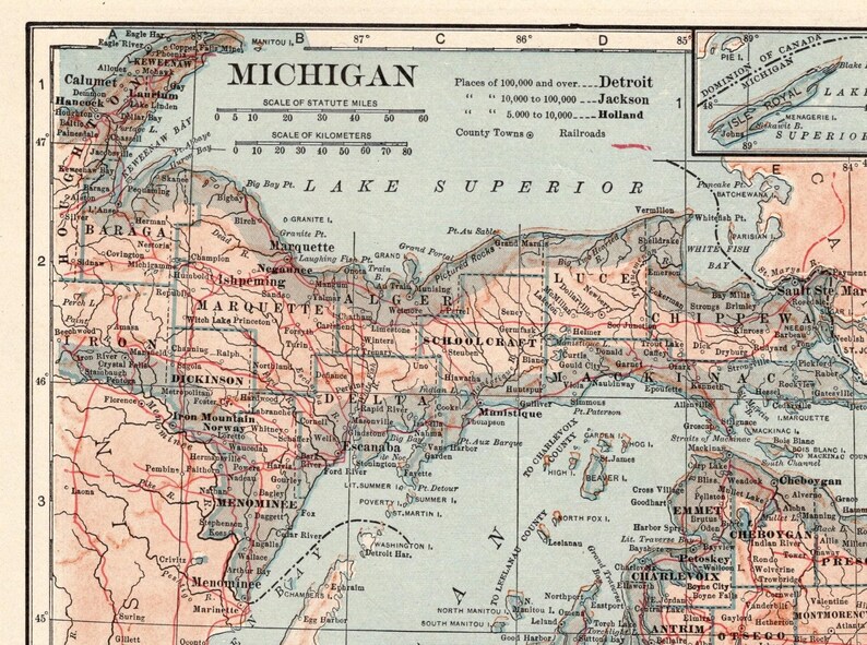 Pode incluir: Um mapa impresso de estilo antigo de Michigan, focado na pen&iacute;nsula superior e &aacute;reas circundantes. O mapa apresenta terra bege, &aacute;gua azul e linhas vermelhas para ferrovias. Inclui uma escala de milhas e quil&ocirc;metros, al&eacute;m de um mapa inserido.