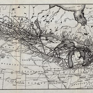 Puede incluir: Un mapa antiguo de América del Norte, que destaca el Ferrocarril Canadiense del Pacífico y sus conexiones. El mapa es en blanco y negro, con líneas detalladas que representan las rutas ferroviarias a través del continente. El texto en la parte inferior dice "Mapa del Ferrocarril Canadiense del Pacífico y Conexiones".