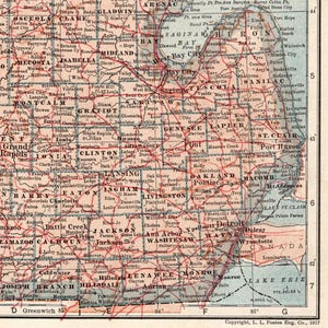Pode incluir: Um mapa antigo do Michigan de 1917 com condados, cidades e vilas impressos em tinta preta sobre um fundo bege claro. Linhas vermelhas indicam rotas de transporte pelo estado, com o lago Huron, o lago St. Clair e o lago Erie vis&iacute;veis.