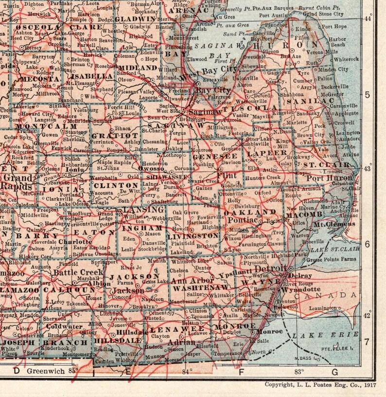 Pode incluir: Um mapa antigo do Michigan de 1917 com condados, cidades e vilas impressos em tinta preta sobre um fundo bege claro. Linhas vermelhas indicam rotas de transporte pelo estado, com o lago Huron, o lago St. Clair e o lago Erie vis&iacute;veis.