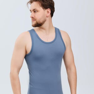 以下が含まれることがあります： ブルーグレーのタンクトップとボクサーパンツのセット。タンクトップは丸首で、体にフィットするシルエットです。ショーツはクラシックなボクサータイプです。生地は柔らかく、軽い素材のようです。快適さとカジュアルな着こなしのためにデザインされています。