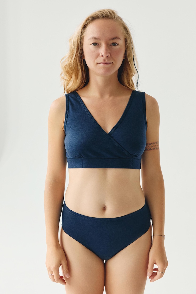 Op de afbeelding: Een marineblauwe, mouwloze, wikkel-bh en bijpassende, hoge taille onderbroek.