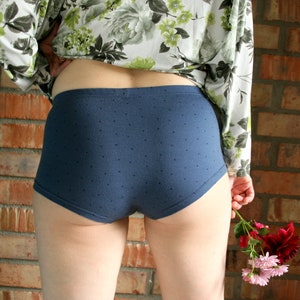 May include: A pair of blue polka dot underwear with a floral print shirt.
