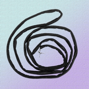 May include: A black cord or ribbon coiled into a circle on a light blue and purple background.