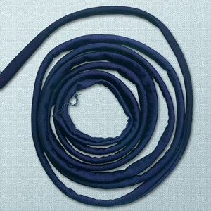 May include: A coiled length of dark blue fabric trim. The trim is approximately 1.5 inches wide and has a smooth, silky texture.