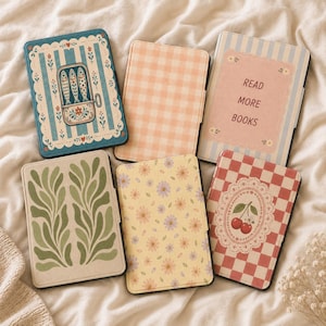 Op de afbeelding: Vijf rechthoekige e-readerhoezen met diverse ontwerpen: een blauwe sardineblik-print, een perzikkleurig gingham-patroon, een blauwgestreepte hoes met de tekst READ MORE BOOKS, een groen bladmotief, een gele bloemenprint en een rood geblokt kersendesign.