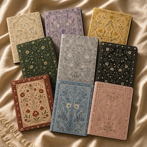 May include: A collection of nine rectangular notebooks featuring intricate floral patterns in various colors including cream, purple, yellow, dark green, grey, black, red, blue, and pink, each with a decorative border and a central botanical design.