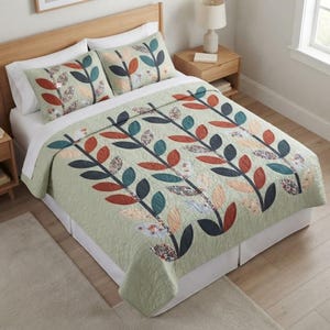 Puede incluir: Una colcha de color verde salvia y dos fundas de almohada a juego con un patrón repetitivo de ramas verticales estilizadas con hojas en tonos azul verdoso oscuro, naranja quemado y crema, con algunas hojas mostrando un pequeño estampado floral.