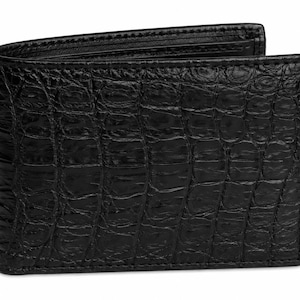 May include: A black bifold wallet featuring a textured, embossed surface that mimics the appearance of crocodile skin. The wallet is constructed with a rectangular shape, clean stitched edges, and a glossy finish, showing a folded design.