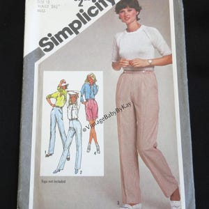 May include: A Simplicity sewing pattern envelope, number 9835, for size 12 with a 26.5 inch waist. The cover features an illustration of a person wearing a white short-sleeved sweater and light-colored pinstriped trousers, with additional clothing sketches.