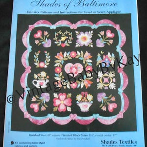 May include: A pattern for a quilt titled "Shades of Baltimore" with instructions for fused or sewn appliqué. The design features floral and heart motifs in pink, blue, and white on a black background. Finished size is 45 inches square.