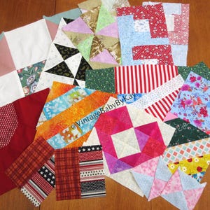 May include: A collection of colorful quilt blocks in various sizes and patterns. The blocks feature a mix of floral, striped, and geometric designs in red, blue, green, and orange hues. Some blocks have star and pinwheel patterns.