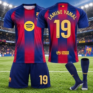 Może przedstawiać: Zestaw piłkarski FC Barcelona składający się z niebiesko-czerwonej koszulki w paski z logo Spotify, numerem 19 i nazwiskiem Lamine Yamal na plecach, pasujących niebieskich spodenek z numerem 19 oraz niebieskich skarpet z napisem Barca.