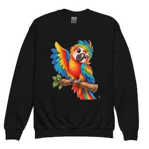 May include: A black long-sleeved sweatshirt featuring a colourful graphic of a parrot with bright red, yellow, and blue feathers perched on a brown tree branch. The parrot has large eyes and is depicted with one wing raised in a waving motion.