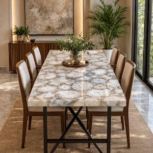 May include: A rectangular dining table featuring a tabletop composed of polished, translucent white and grey agate stone slices. The table is supported by a black metal frame with an X-shaped base and is surrounded by six chairs with wooden frames.