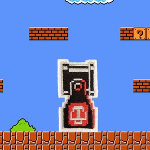 May include: A black and red patch featuring a pixelated design of a video game character, set against a blue sky background with brick platforms, question mark blocks, and a green bush. The patch has a white border.