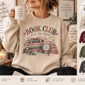 Könnte beinhalten: Ein beigefarbenes Sweatshirt mit Rundhalsausschnitt und einer Grafik aus einem Bücherstapel mit rosa Schleife, einer Tasse mit Leopardenmuster und der Aufschrift 'Just One More Chapter' sowie einer Brille. Der Text 'BOOK CLUB Read Sip Repeat' steht darüber.