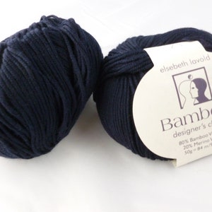 May include: Two balls of dark blue yarn labeled "Bambool designer's choice 80% Bamboo Viscose 20% Merino Wool 50g - 84 m/92 yd" by elsebeth lavold.