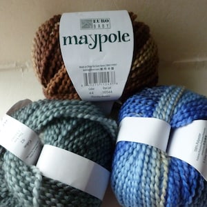 May include: Three skeins of Euro Baby Maypole yarn. The skeins are in brown and beige, blue and white, and gray and white.