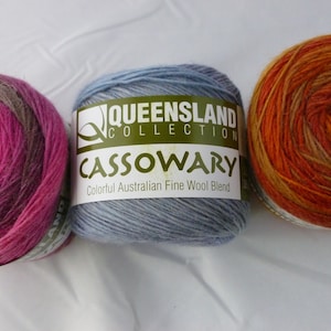 May include: Three skeins of yarn in different color combinations. The yarn is labeled "Queensland Collection Cassowary Colorful Australian Fine Wool Blend."