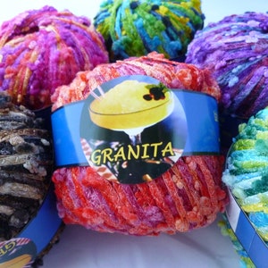 May include: Assortment of colorful yarn balls with a label that reads "Granita". The yarn is fluffy and textured, with a variety of colors including pink, purple, blue, green, and brown.