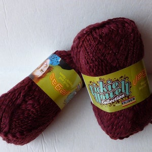 May include: Two skeins of burgundy yarn with a shimmery finish. The yarn is labeled "Liccie Howell Collection" and "Segal".