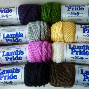 May include: Assortment of ten skeins of Lamb's Pride Bulky yarn in various colors, including purple, green, yellow, white, pink, black, brown, and gray. Each skein has a label that reads "Lamb's Pride - Bulky - 85% Wool / 15% Mohair".