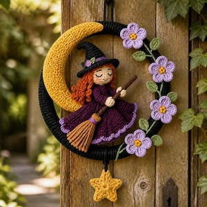 Puede incluir: Un adorno de pared de ganchillo con un marco circular negro, una luna creciente amarilla, una pequeña bruja de pelo rojo con vestido morado y sombrero negro sobre una escoba, flores moradas con hojas verdes y una estrella amarilla colgante.