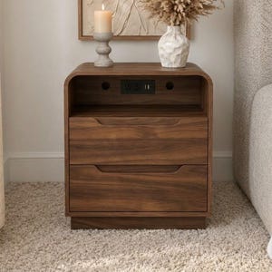 May include: A dark wood nightstand with two drawers and an open top shelf featuring a built-in power outlet with two electrical sockets and two USB ports. The nightstand has a curved frame design and integrated handles on the drawer fronts.
