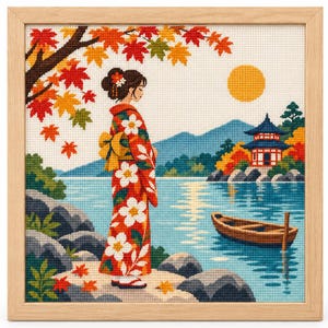 May include: A framed cross-stitch embroidery depicting a person in a red floral kimono standing by a lake. The scene includes a wooden boat, a pagoda, mountains, a yellow sun, and autumn maple leaves in shades of red, orange, and yellow.