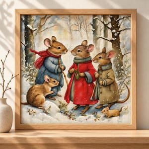 May include: A framed cross-stitch embroidery depicting five brown mice in a snowy forest. Three mice stand wearing winter coats and scarves in red, blue, and tan, while two smaller mice sit on the snow. The scene features trees and light snowfall.