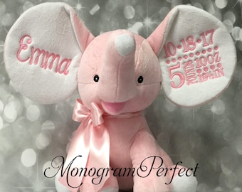 May include: Pink plush elephant with white ears, a pink bow, and embroidered details. The ears are personalized with the name "Emma" and the date "10-18-17" with birth stats.