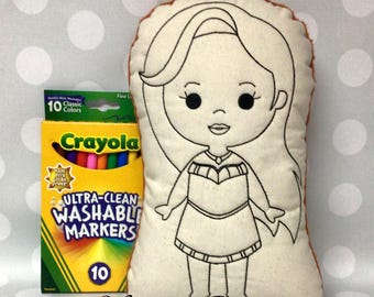 May include: A beige fabric doll with a black outline of a cartoon character, next to a box of Crayola Ultra-Clean Washable Markers. The doll has long hair and a dress. The box of markers has 10 classic colors.