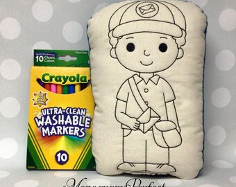 May include: A cream-colored pillow with a black outline of a mail carrier, a hat, and a mailbag. Next to it is a box of Crayola Ultra-Clean Washable Markers, 10 classic colors. The text "Monogram Perfect" is at the bottom.