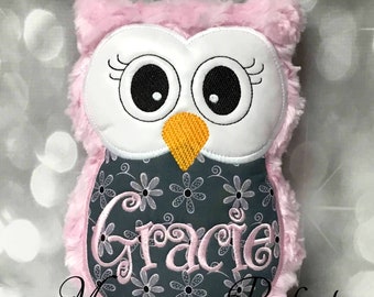 May include: Pink plush owl with embroidered white eyes, a yellow beak, and a gray body with a white floral pattern. The owl has the name "Gracie" embroidered on the front in pink.