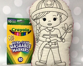 May include: A coloring book style plush doll of a firefighter holding a hose, next to a box of Crayola Ultra-Clean Washable Markers with 10 classic colors. The doll has a red border and the text "Monogram Perfect" is at the bottom.
