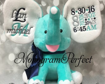 May include: A turquoise plush elephant with white ears and a pink mouth. The ears are embroidered with the baby's name, birth date, weight, and time of birth. The elephant is sitting on a white surface. The text on the ears reads: "Liam Michael 8-30-16 8 pounds 3 oz 20 1/2 in 6:45 AM"