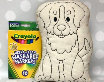 May include: A beige dog-shaped pillow with black outline details, next to a box of 10 Crayola Ultra-Clean Washable Markers. The box is yellow and green with the text "Crayola" and "10 Classic Colors". The pillow has the text "Monogram Perfect".