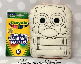 May include: A cream-colored owl-shaped pillow with black outline details, perched on books. A box of Crayola Ultra-Clean Washable Markers in various colors is next to the pillow. The text "Monogram Perfect" is at the bottom.