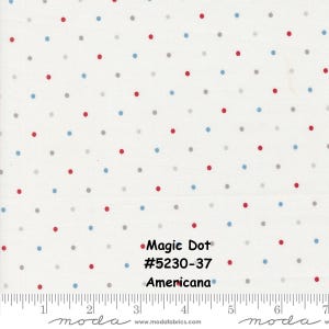 May include: Cream-coloured fabric featuring a polka dot design in red, grey, and blue. The text "Magic Dot", "#5230-37", and "Americana" are printed on the fabric. A ruler is along the bottom edge.
